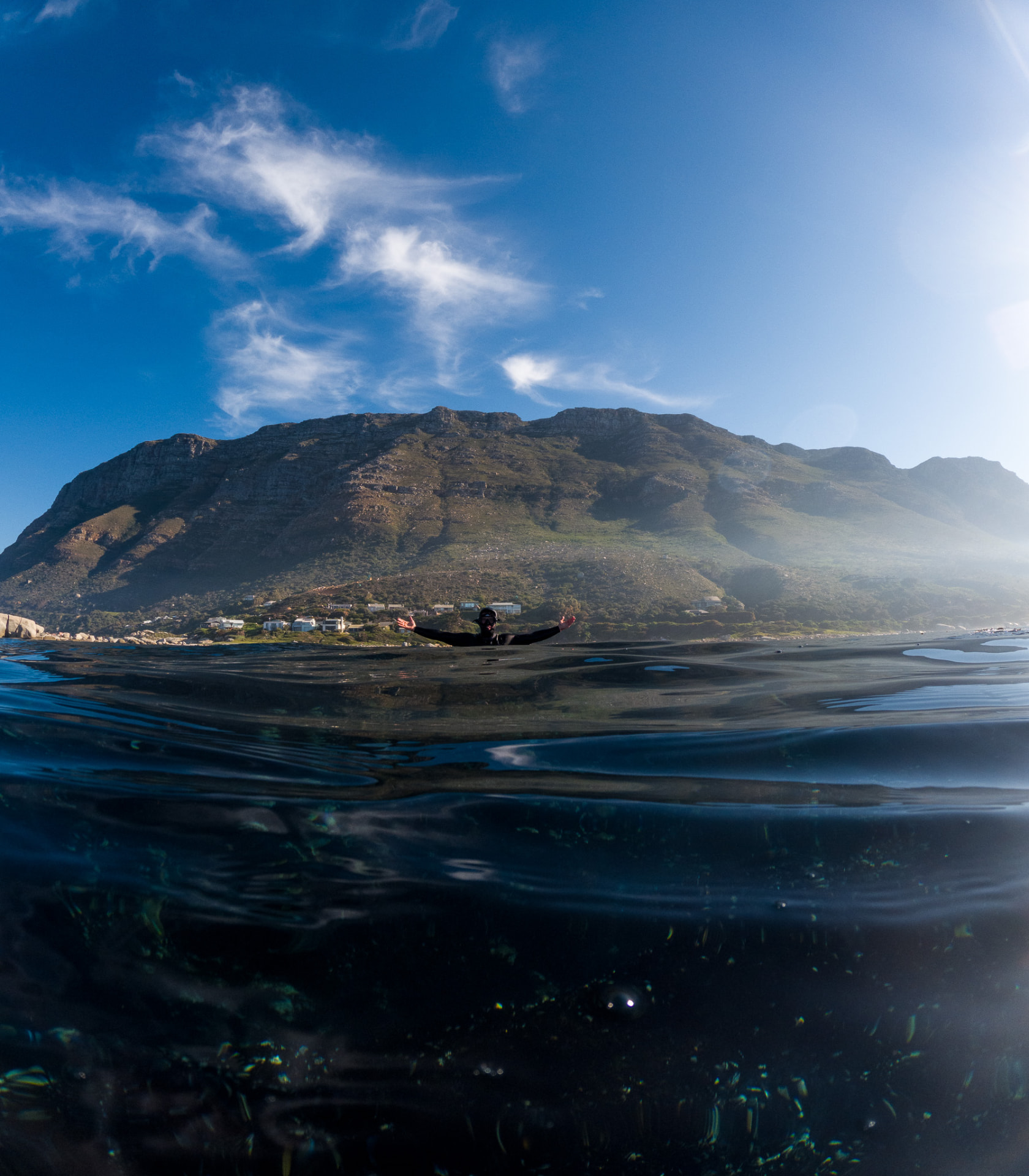 Swimmer floating at the surface with mountains behind