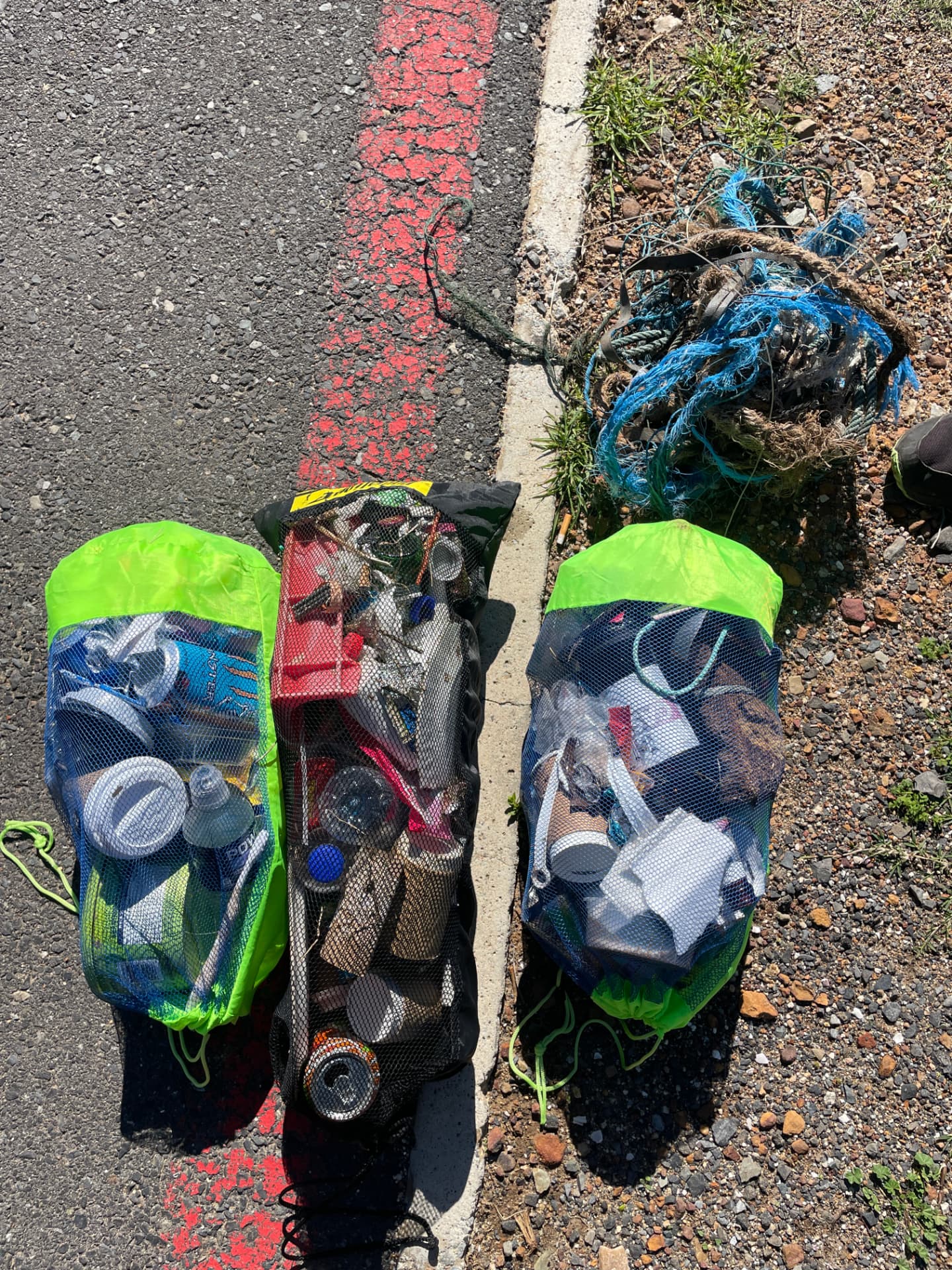 Mesh bags full of cans, bottles and plastic collected from the coast