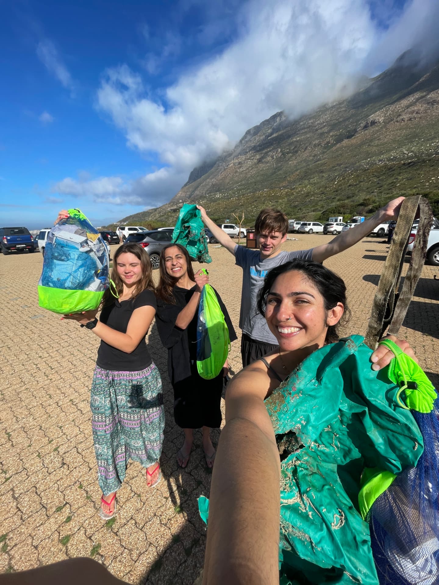Volunteers selfie with bags of collected trash on the beach