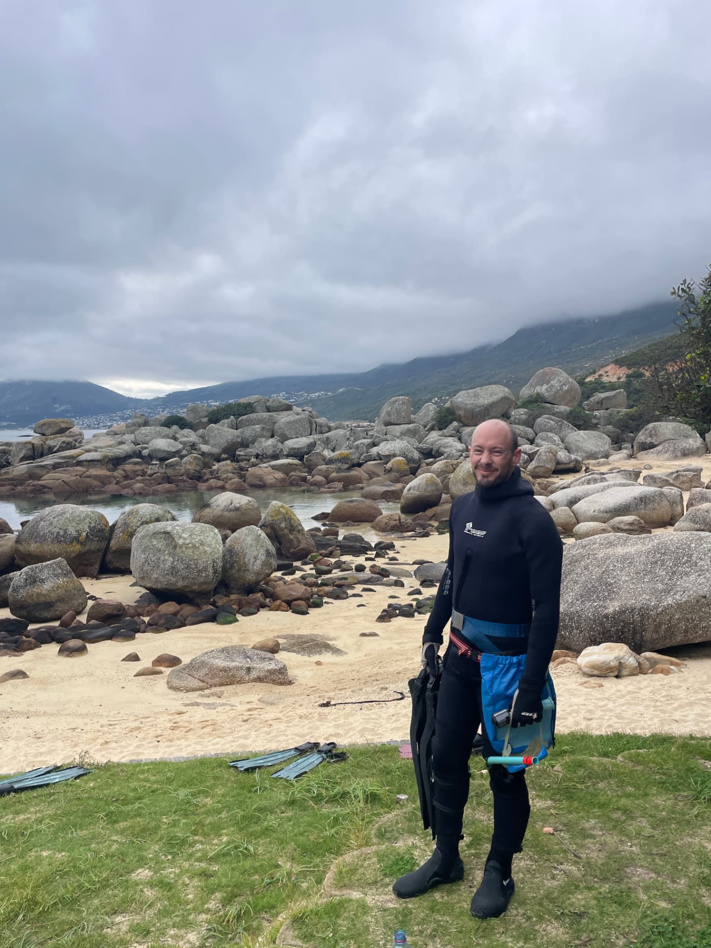 Freediver in a wetsuit with fins on the beach after a swim